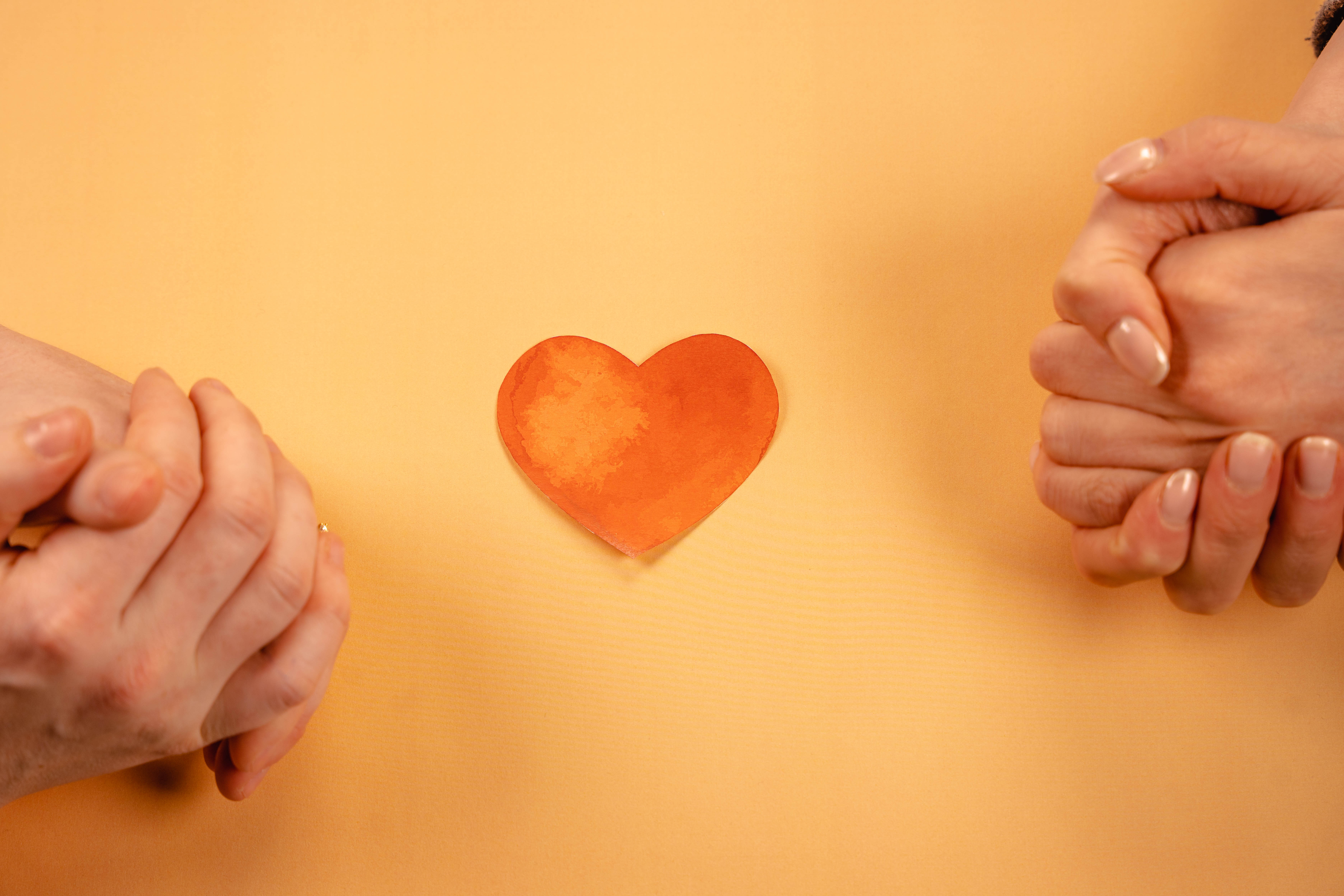 to sett med foldede hender med et hjerte i midten. 