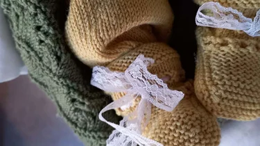 nærbilde av babyføtter med strikkede sokker på.