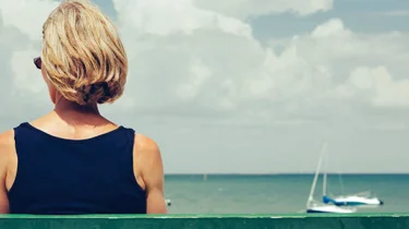 Kvinne sitter på en benk