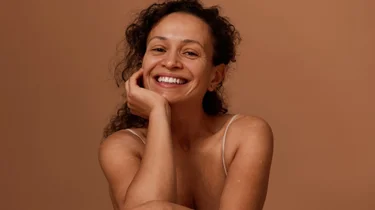 Smilende kvinne i studiobakgrunn