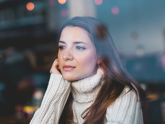 ung kvinne som stirrer ut vinduet.